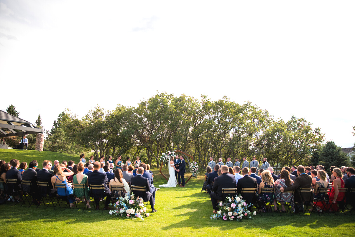 A wedding ceremony on the lawn at The Oaks at Plum Creek in Denver, Colorado.