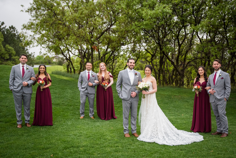 A group of bridesmaids and groomsmen pose for a photo at The Oaks at Plum Creek, in Denver, Colorado.